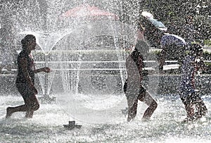 Kids play in a water of a fountain on a sunny summer day during summer break in Sofia, Bulgaria Ã¢â¬â june 15, 2012. Sunny weather c